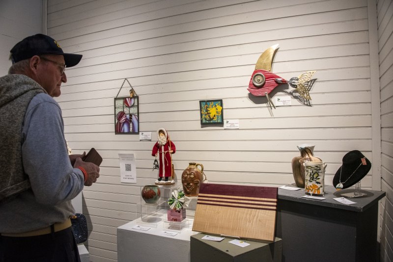 A guest looks at items donated by the artists for the online auction.